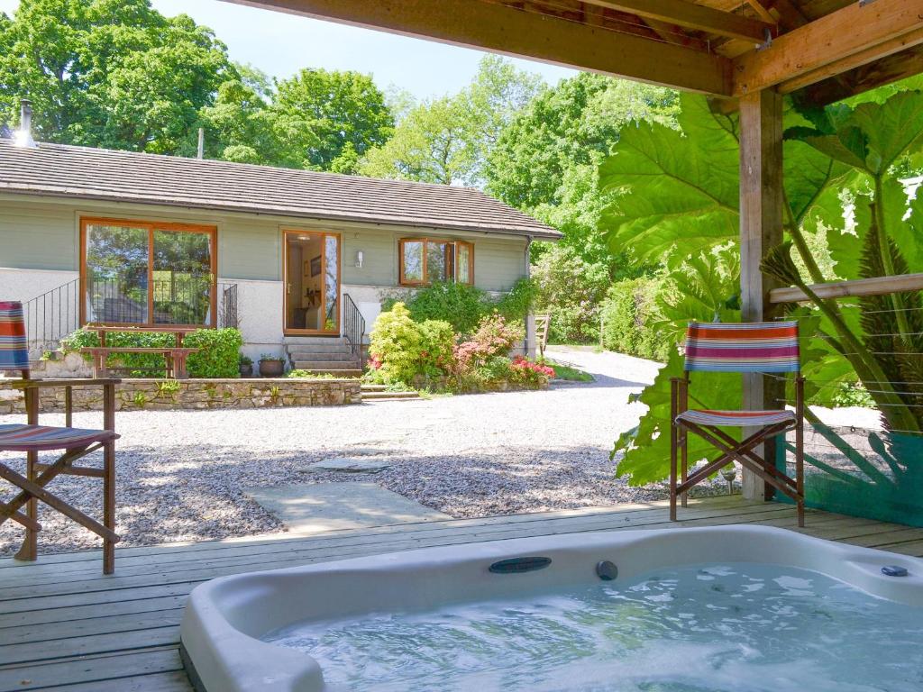 a jacuzzi tub on a deck with a house at Tigh A Vullin - S4628 in Ardfern