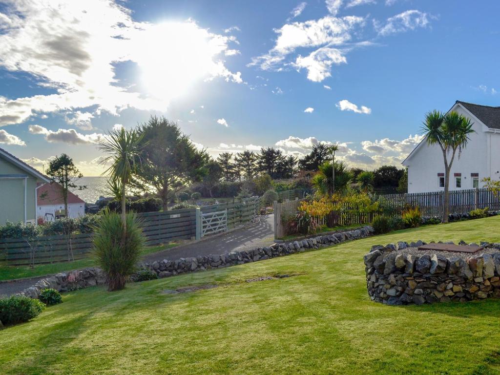 a yard with a stone wall and a fence at Seaward in Portpatrick