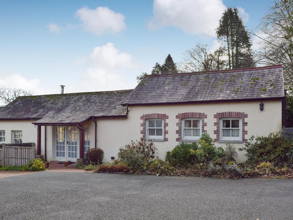 a white house with a gray roof at Gwili Cottage in Llanfynydd