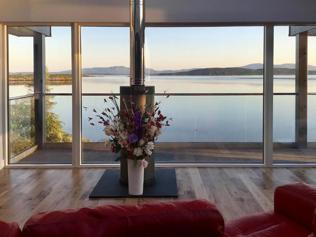 a living room with a vase of flowers on a table at Tidereach - Otters View in Connel