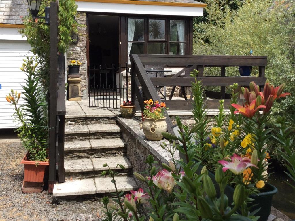 un escalier menant à une maison fleurie dans l'établissement Mill Cottage, Marsh Mills, à Aveton Gifford