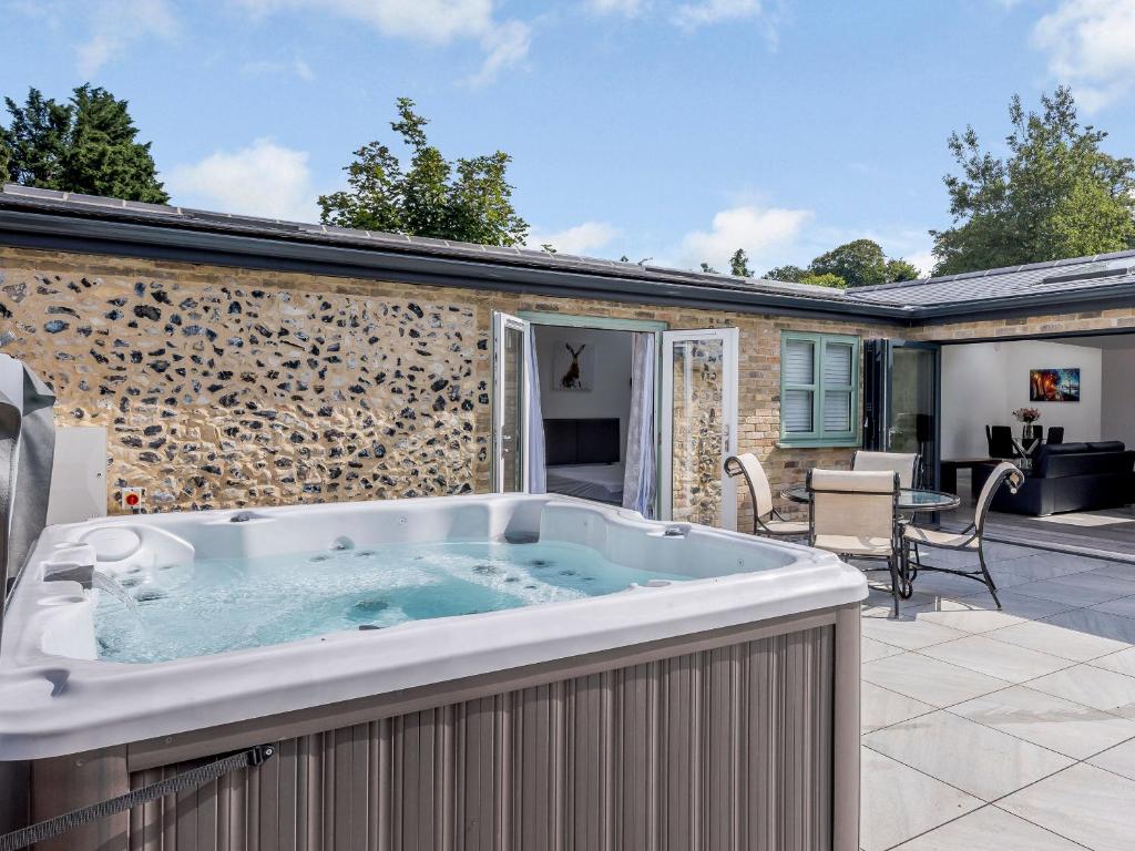 a hot tub on the patio of a house at Marshall Cottage in Santon