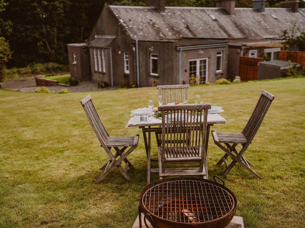 a table with chairs and a grill in a yard at Wild Geese Lodge - Uk31046 in Portpatrick
