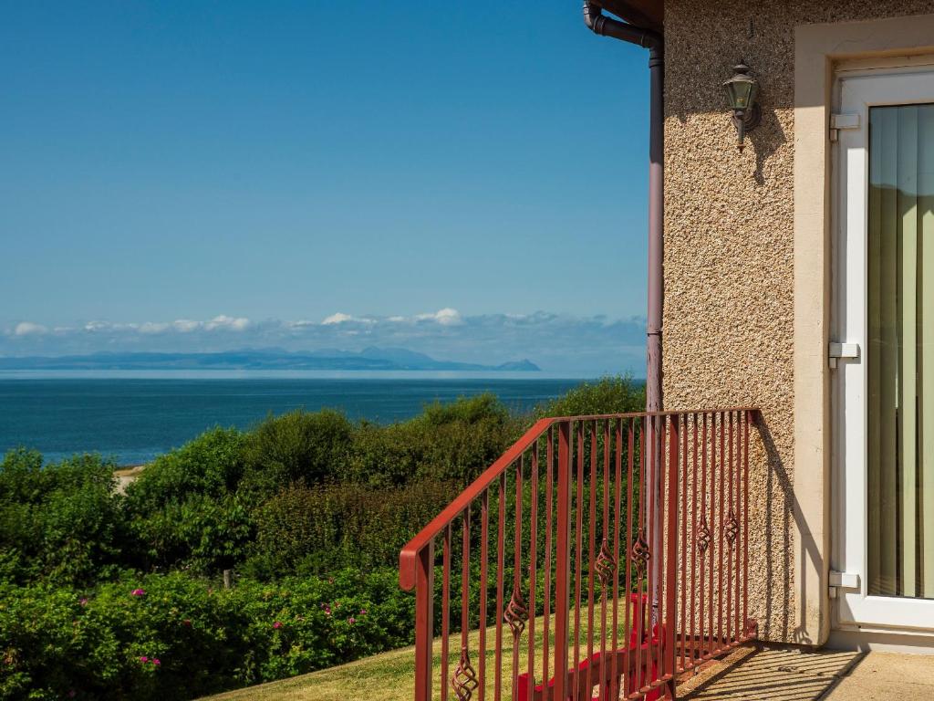 uma varanda de uma casa com vista para o oceano em Cairn-o-mhor em Lendalfoot