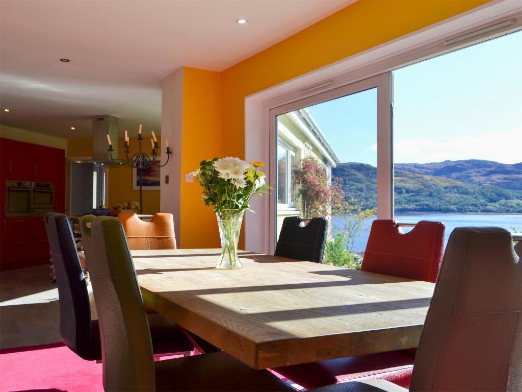 Glencripesdale的住宿－The Steading，一间带桌子和大窗户的用餐室
