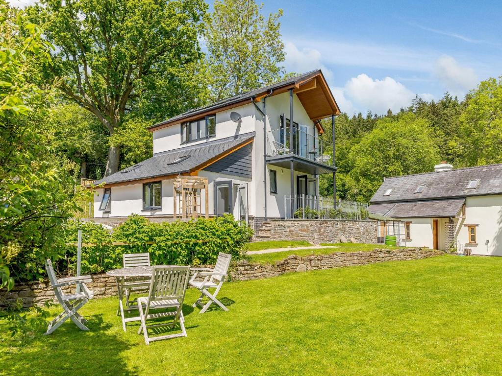 a house with a yard with chairs in front of it at Barn Owls Rest in Clyro