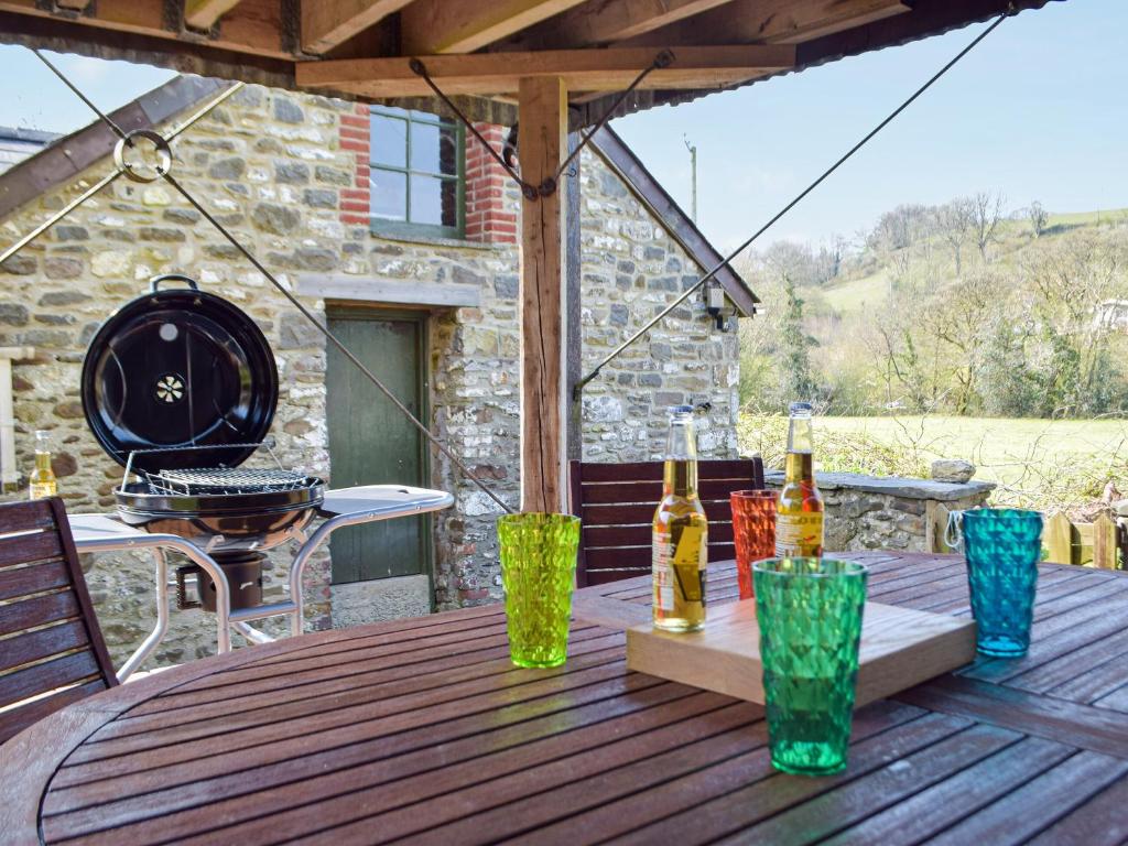 a wooden table with bottles and glasses on a deck at Tynval in Carmarthen