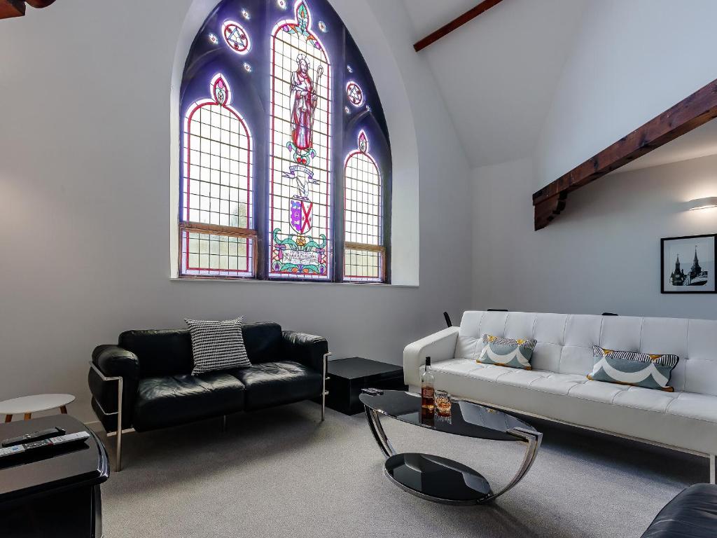 a living room with a couch and a stained glass window at Torreagles in Mintlaw