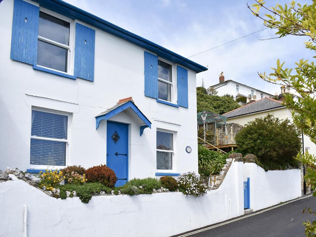 Casa blanca con ventanas azules y puerta azul en Seaport Cottage en Ventnor