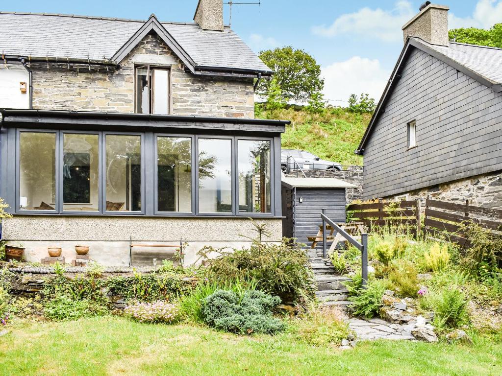 a stone house with large glass windows at Caer Elen in Dolwyddelan