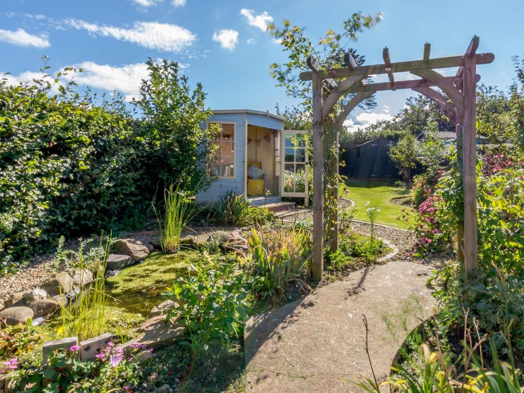 a garden with a pergola and a house at Sea Fever in Scarborough