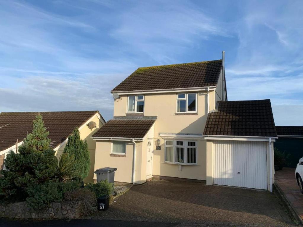 a white house with two garages in a driveway at Paignton View in Paignton