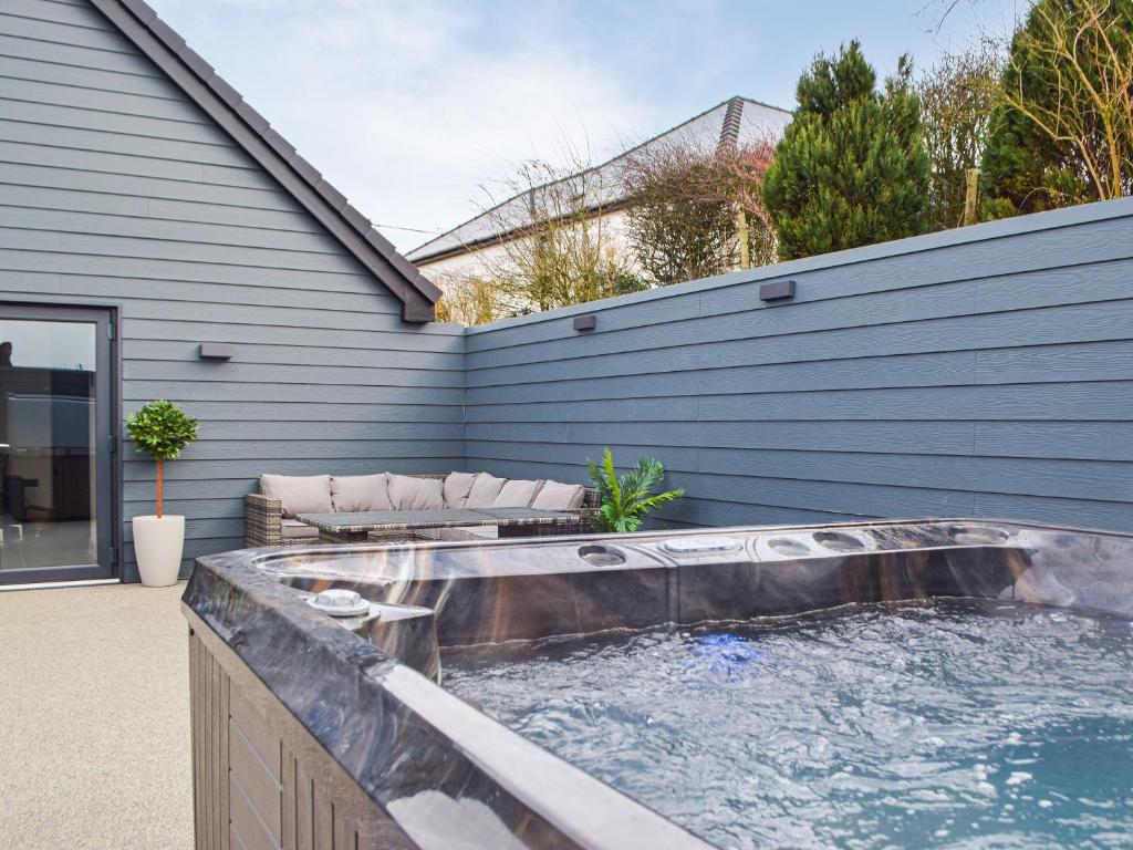 una bañera de hidromasaje en el patio trasero de una casa en Hafan Gwyn en Verwick