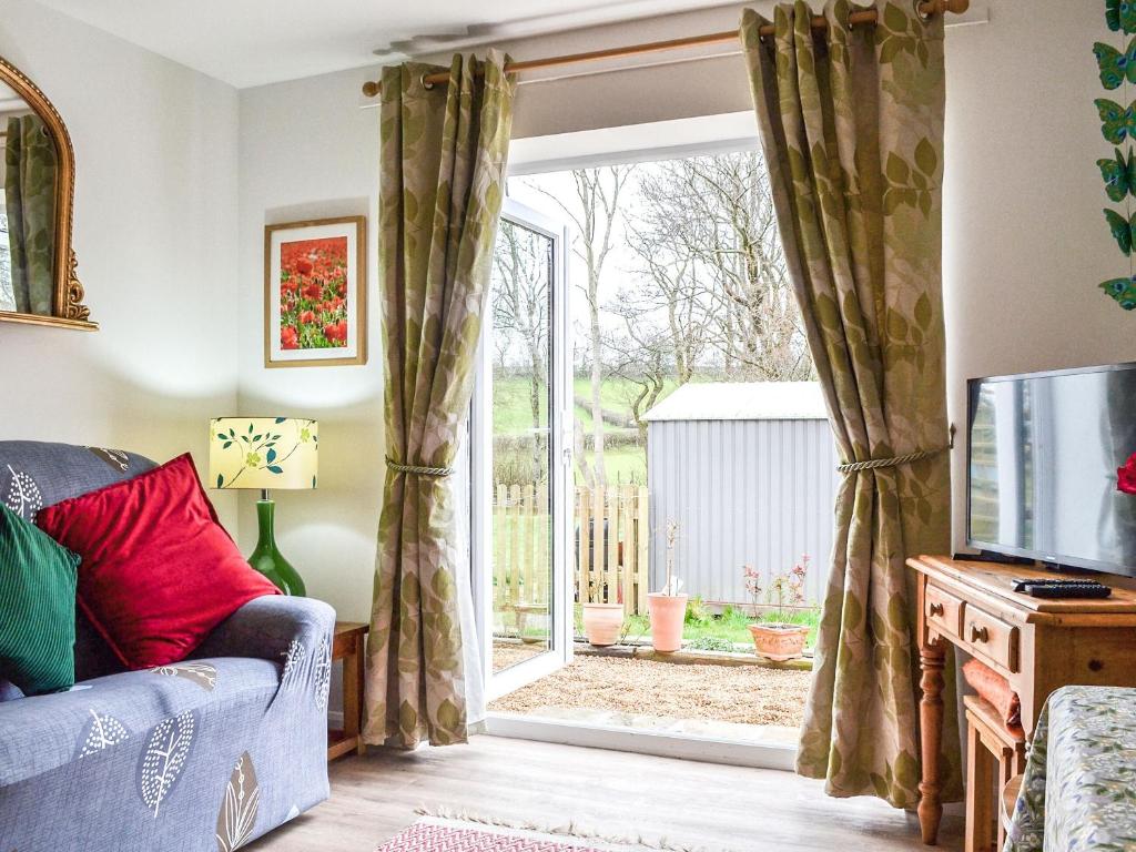 a living room with a sliding glass door at Forest View in Llanfihangel Rhydithon