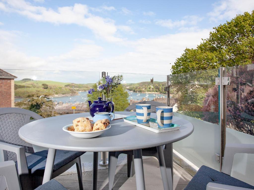 a white table with a plate of food on a balcony at Devon Court 2 in Salcombe