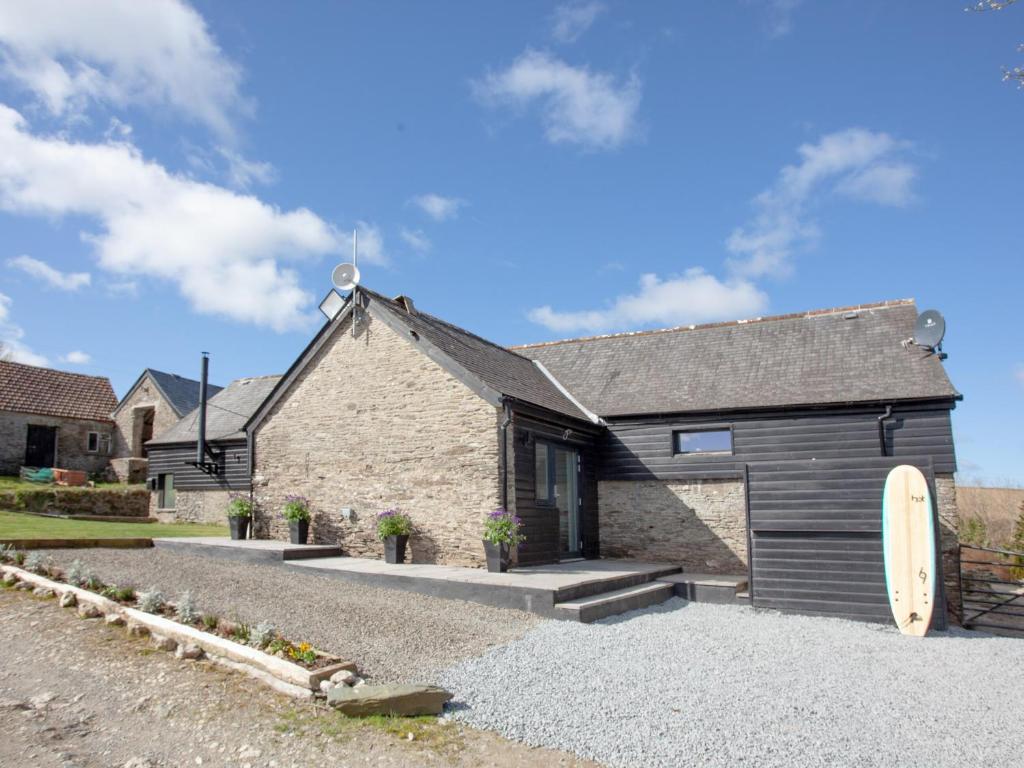 a stone house with a black garage at The Shippon - Uk37467 in Berrynarbor