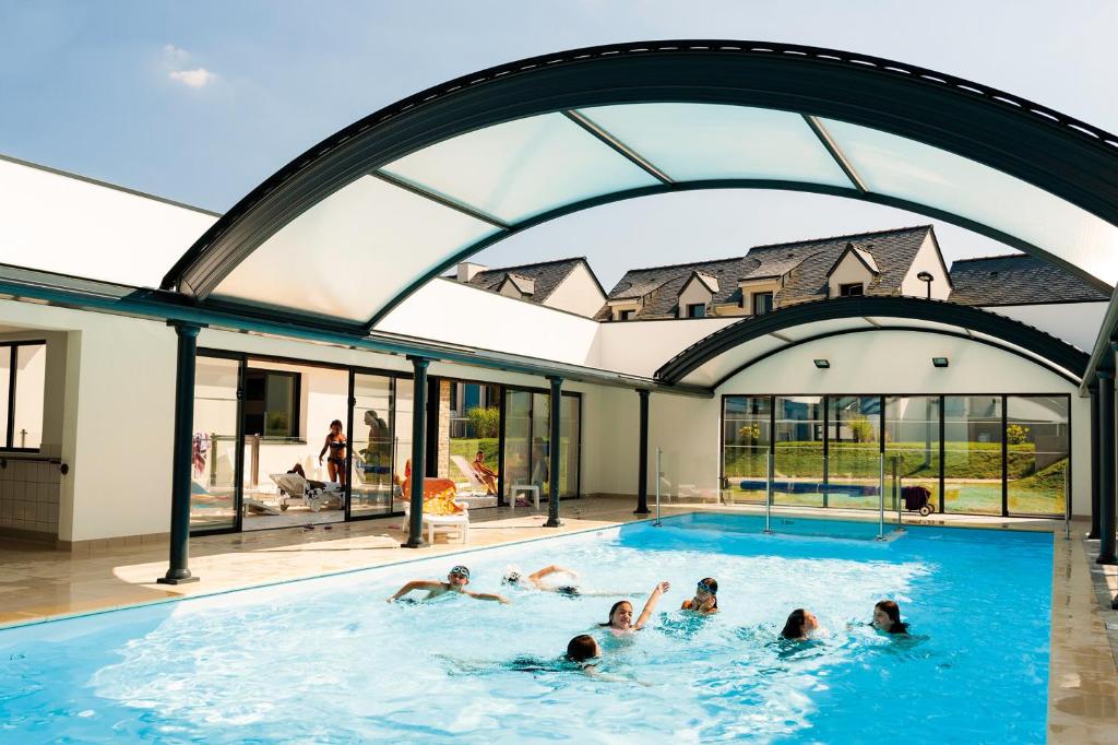 a group of people swimming in a swimming pool at Lagrange Vacances Domaine de Val Queven in Quéven