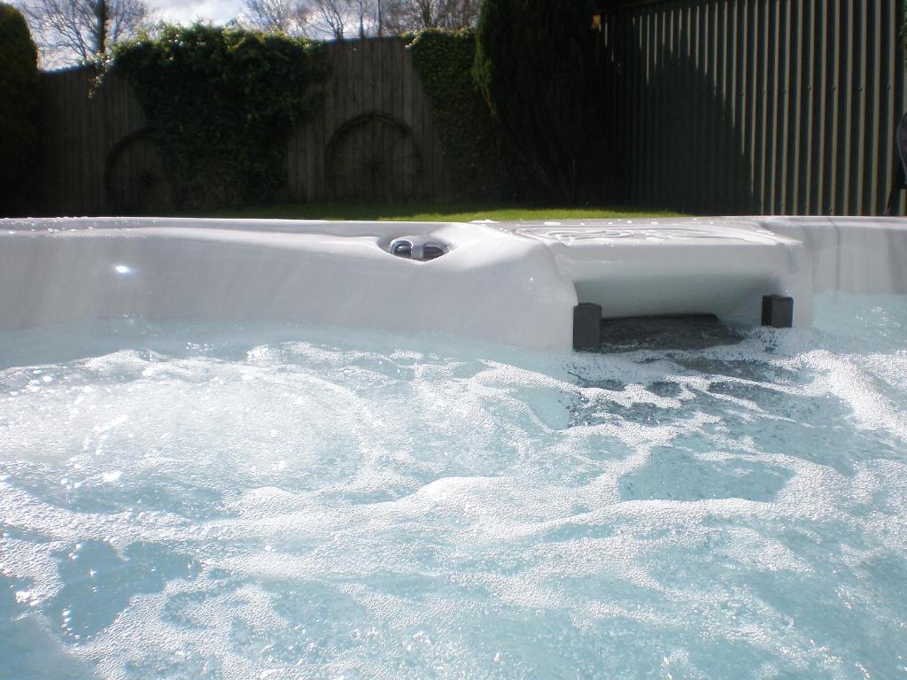 a bath tub filled with water in a yard at Higher Hopworthy Cottage-uk11436 in Pyworthy