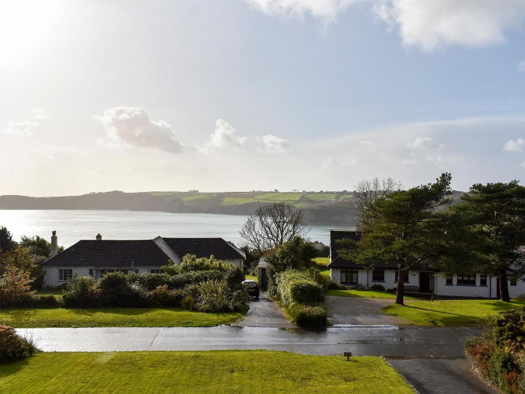 a house on a street with a lake in the background at Bay View in Carlyon Bay