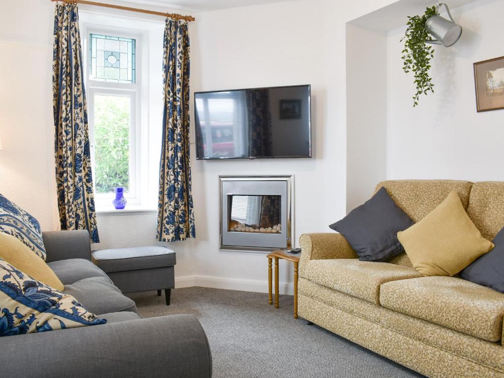 安賽德的住宿－Underhill Cottage，客厅配有沙发和墙上的电视