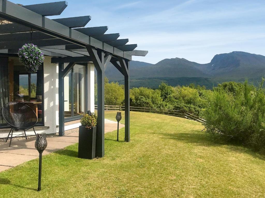 a garden with a pergola with mountains in the background at Cushendall House in Torcastle