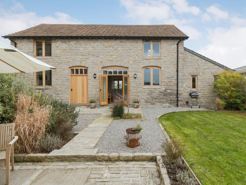 une maison en pierre avec un jardin et une pelouse dans l'établissement Applebarn - Uk10654, à West Pennard