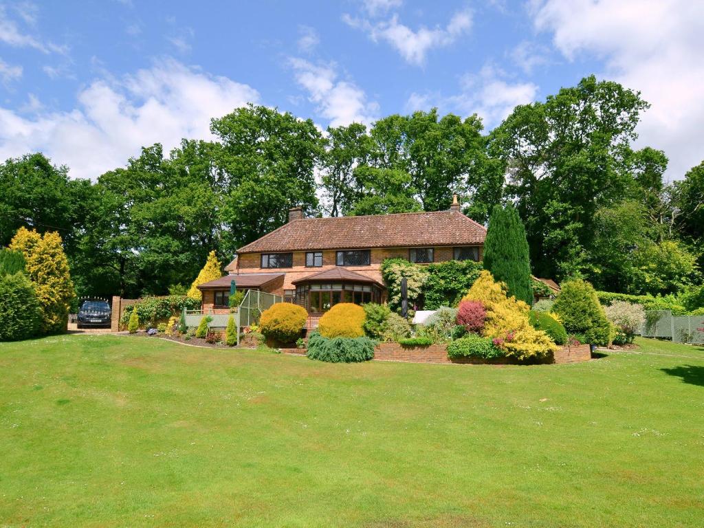 a house with a large yard with bushes at Alices Lodge in Ringwood