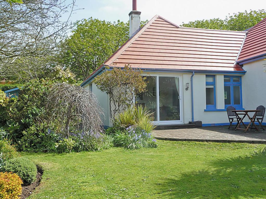 een blauw huis met een tafel en stoelen in een tuin bij Palm Leas - E3587 in Ilfracombe