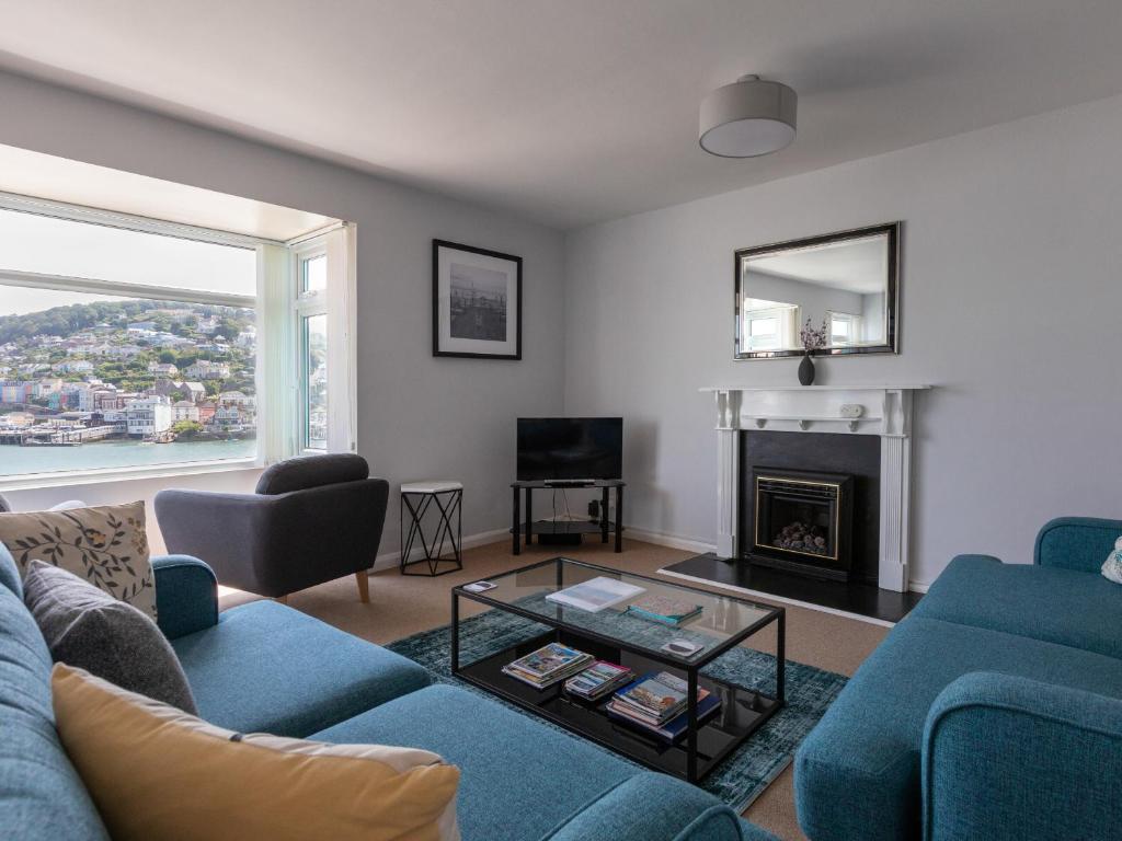 a living room with a blue couch and a fireplace at The Mews Apt 1 Newcomen Road in Dartmouth