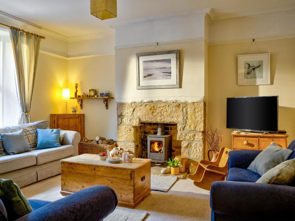 a living room with a couch and a fireplace at The Nook in Alnwick