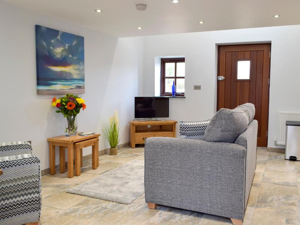 a living room with a chair and a tv at Snowdrop Cottage - Uk12987 in Monington