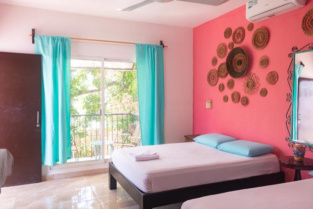 Una cama o camas en una habitación de Hostal Tunich Naj & Hotel