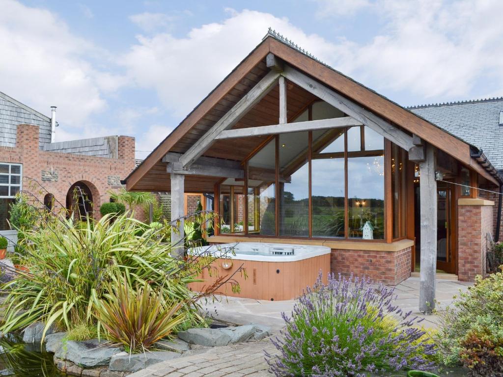 a pavilion with a hot tub in a garden at Carr End Barn A in Preesall