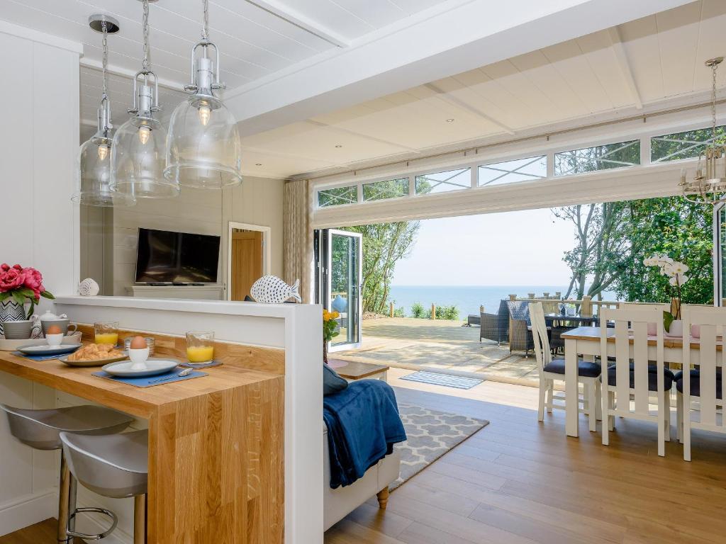 a kitchen and dining room with a view of the ocean at Beach Retreat in Corton