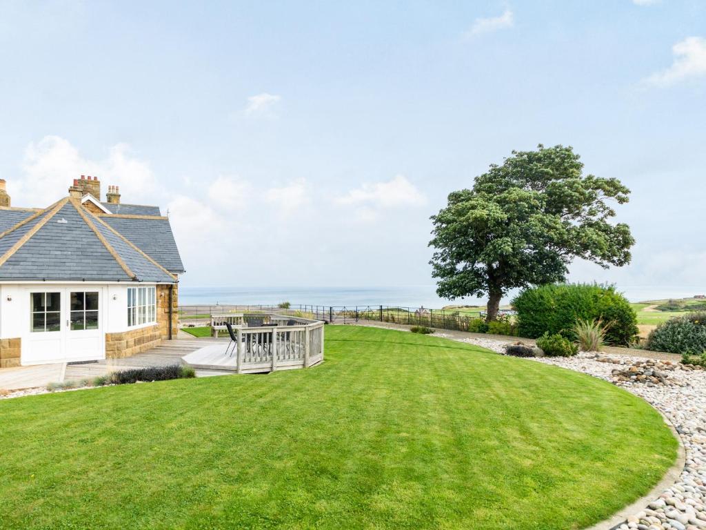 a house with a large lawn and a deck at The Byre in Whitby