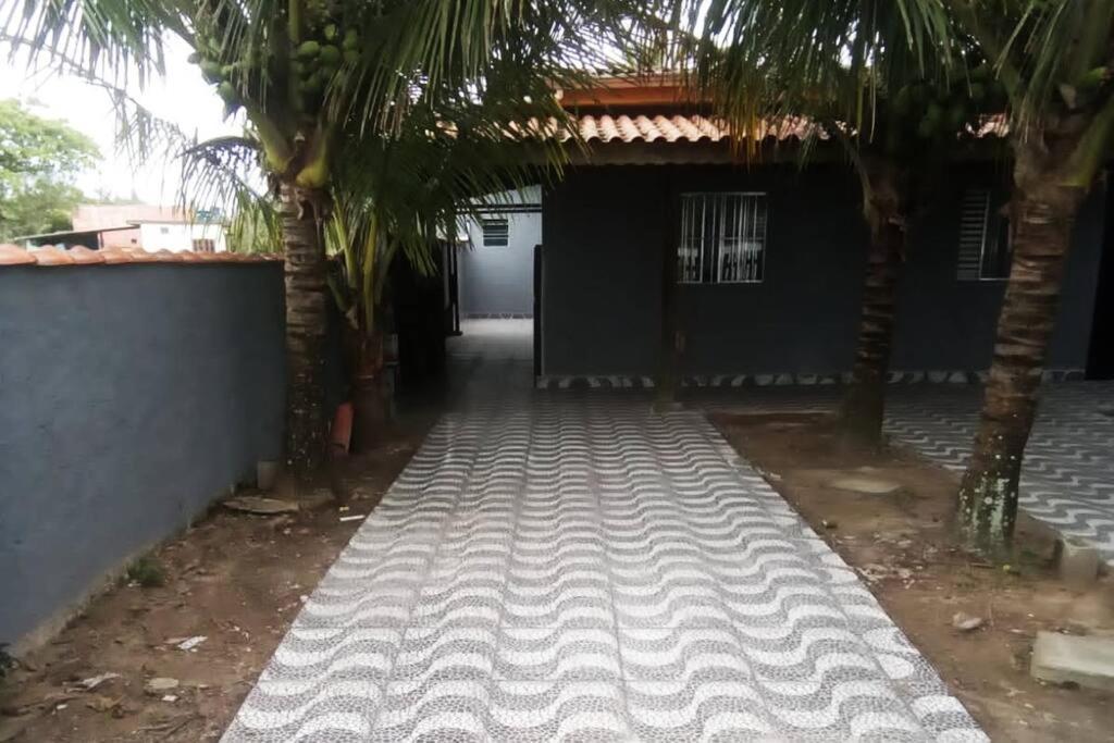 a driveway with palm trees in front of a building at Tropical House in Ilha Comprida