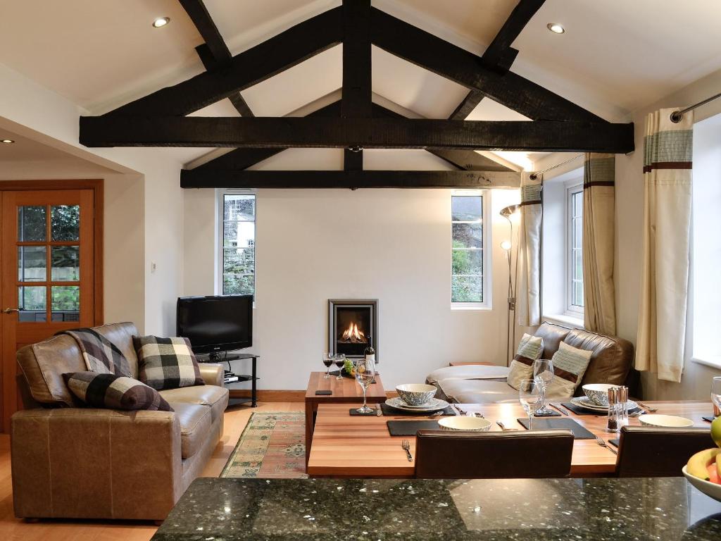 a living room with couches and a table and a fireplace at Castle Howe in Rosthwaite