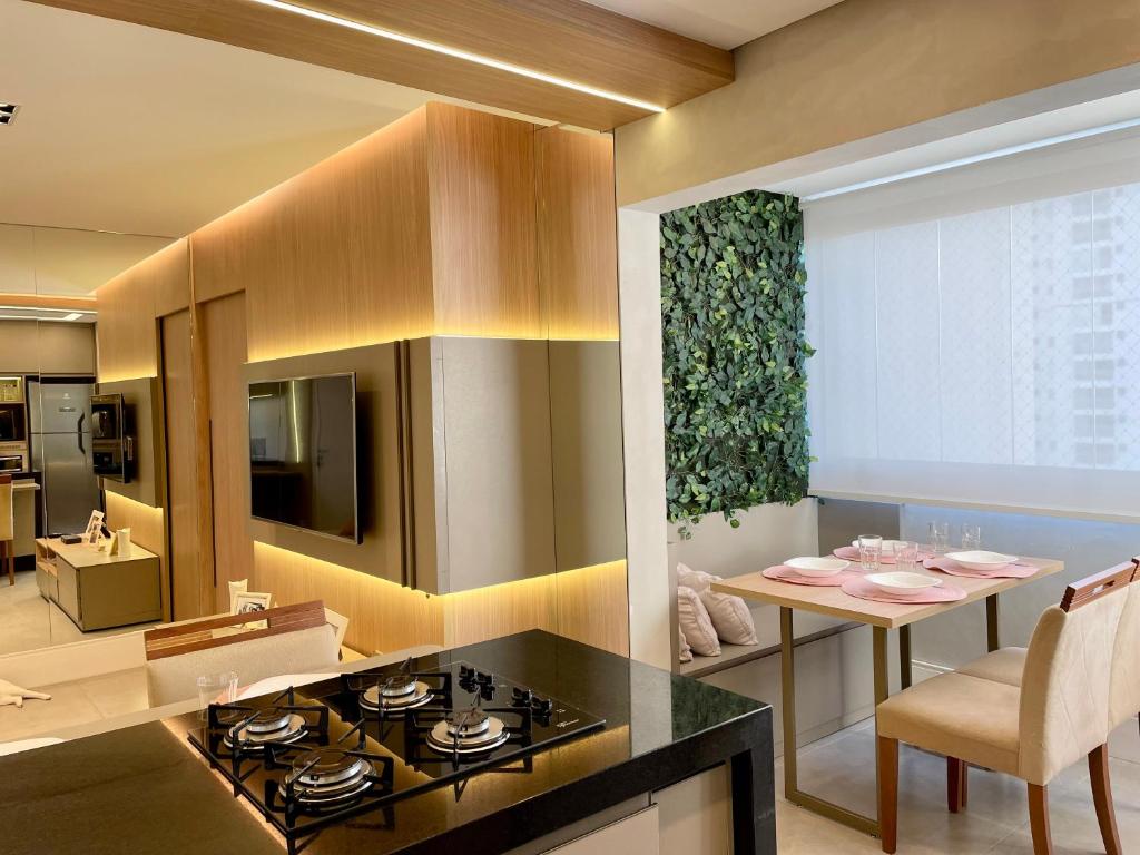 a kitchen and living room with a stove and a table at Apartamento Maravilhoso Maranata Vila Industrial in São José dos Campos