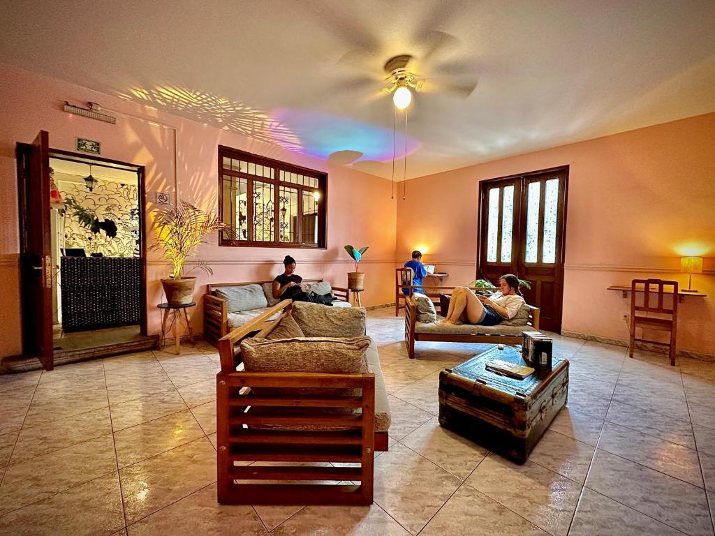 a living room with people sitting on couches at Hostal Central Oaxaca in Oaxaca City