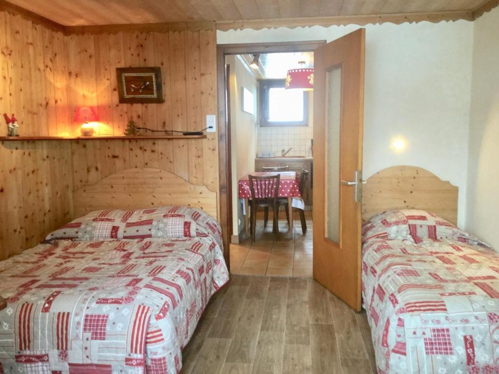 a bedroom with two beds and a table in a room at Appartement Les Gets, 1 pièce, 3 personnes - FR-1-671-129 in Les Gets