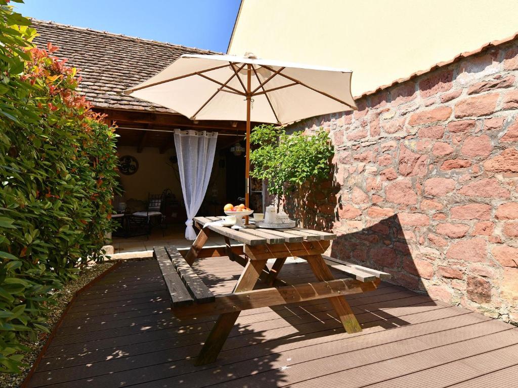 a picnic table and an umbrella on a wooden deck at Charmant F2 avec jardin privatif, climatisation, et parking - Au cœur du vignoble alsacien ! - FR-1-744-1 in Bergholtz