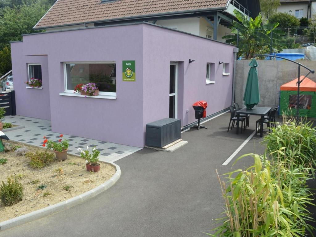 Cette maison violette dispose d'une terrasse et d'une table. dans l'établissement Gîte Altkirch, 3 pièces, 4 personnes - FR-1-744-5, à Altkirch