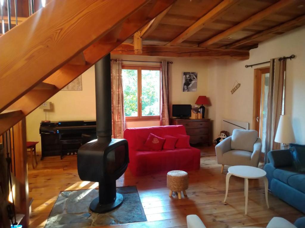 a living room with a red couch and a wood stove at Chalet Valloire, 5 pièces, 12 personnes - FR-1-263-533 in Valloire