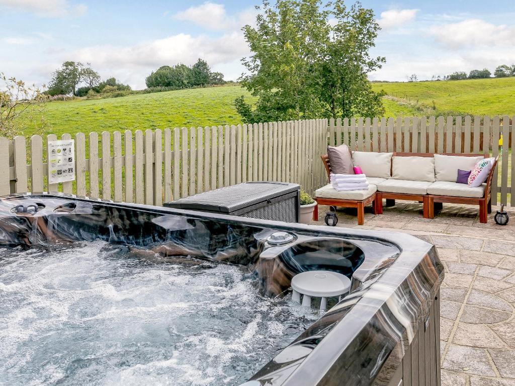 a hot tub in the middle of a patio at Alton Hall Cottage in Ashover