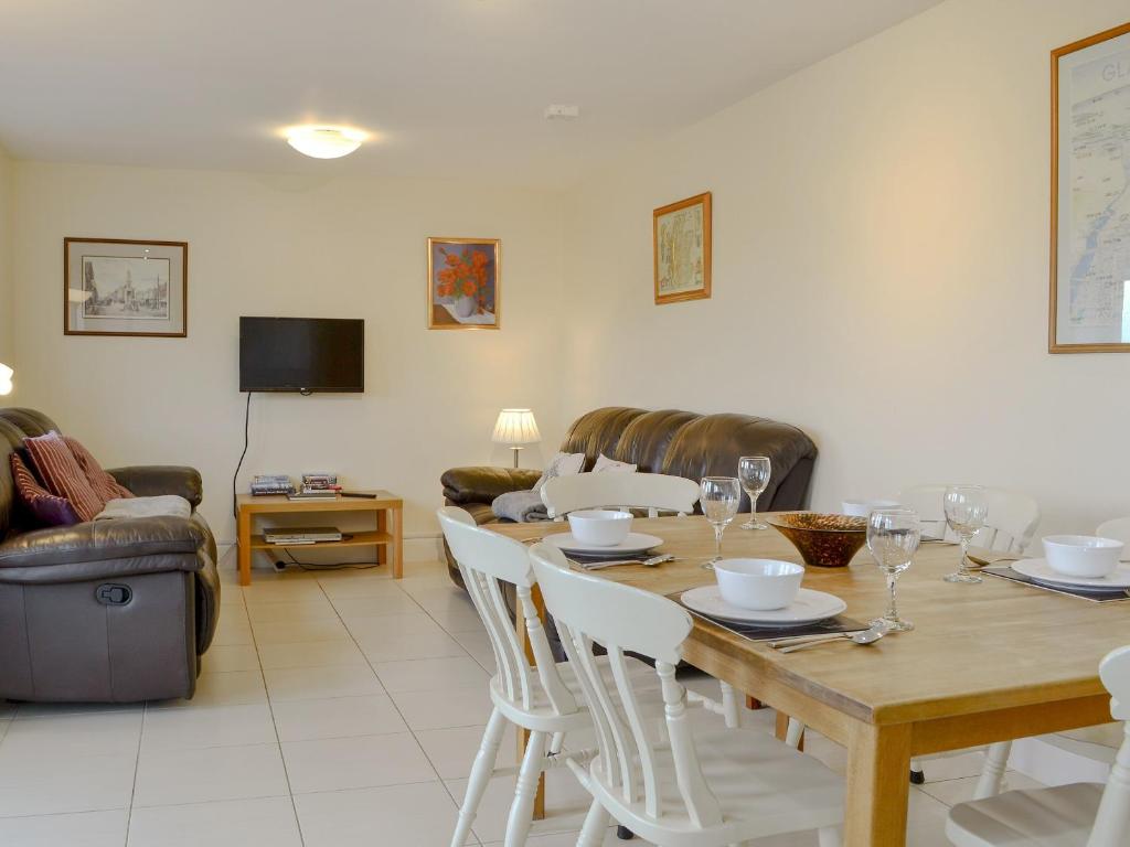 sala de estar con mesa de madera y sillas en Carribber Beech en Torphichen