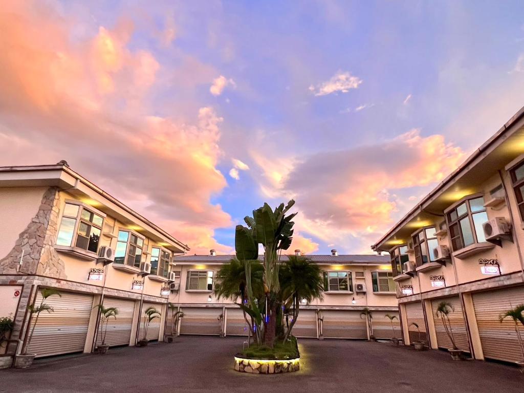 a building with a palm tree in a courtyard at 家園時尚旅店 in Puli