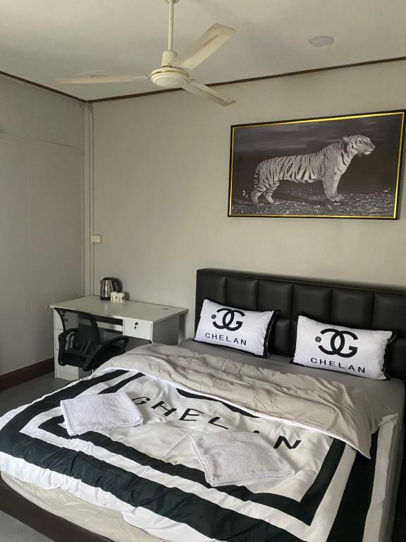 um quarto com uma cama com uma fotografia de um tigre em Batman guesthouse em Vientiane