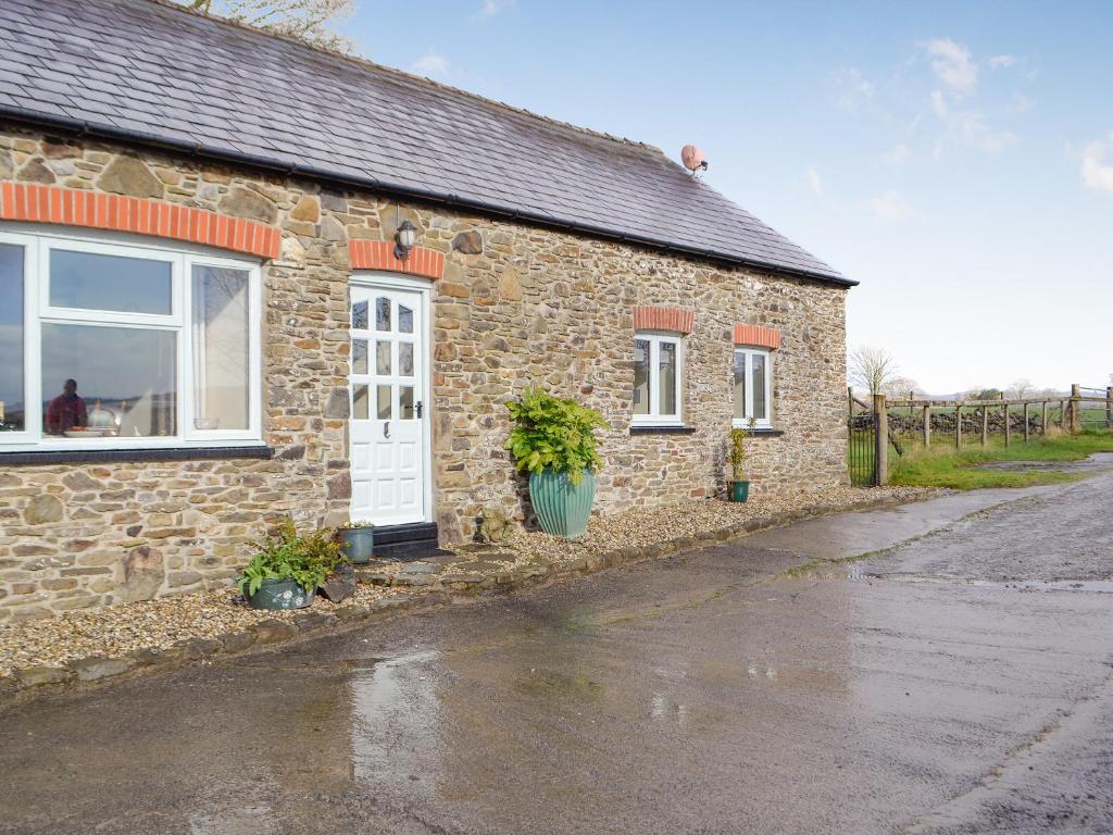 a stone house with a white door and windows at Trefechan in Pumpsaint