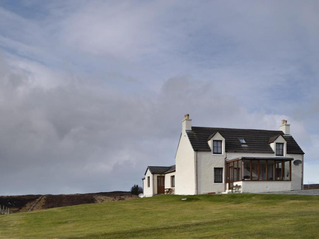 a white house on top of a grassy hill at Hillside - Uk32930 in Gairloch