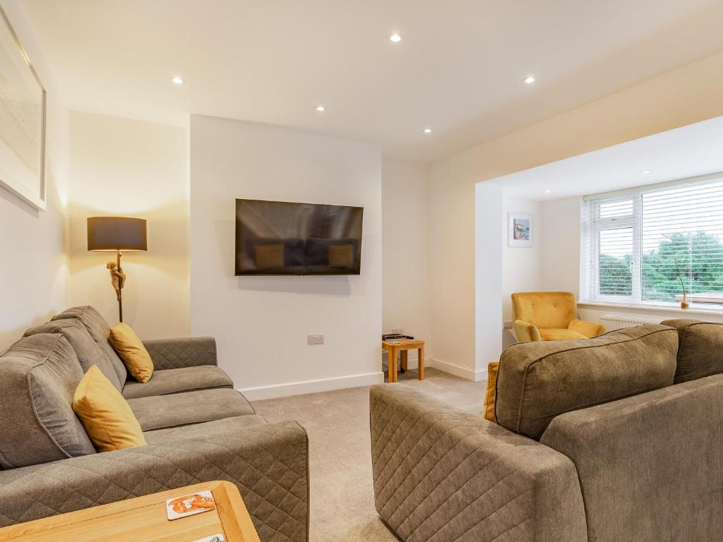 a living room with two couches and a tv at Broadacre House in Brixham